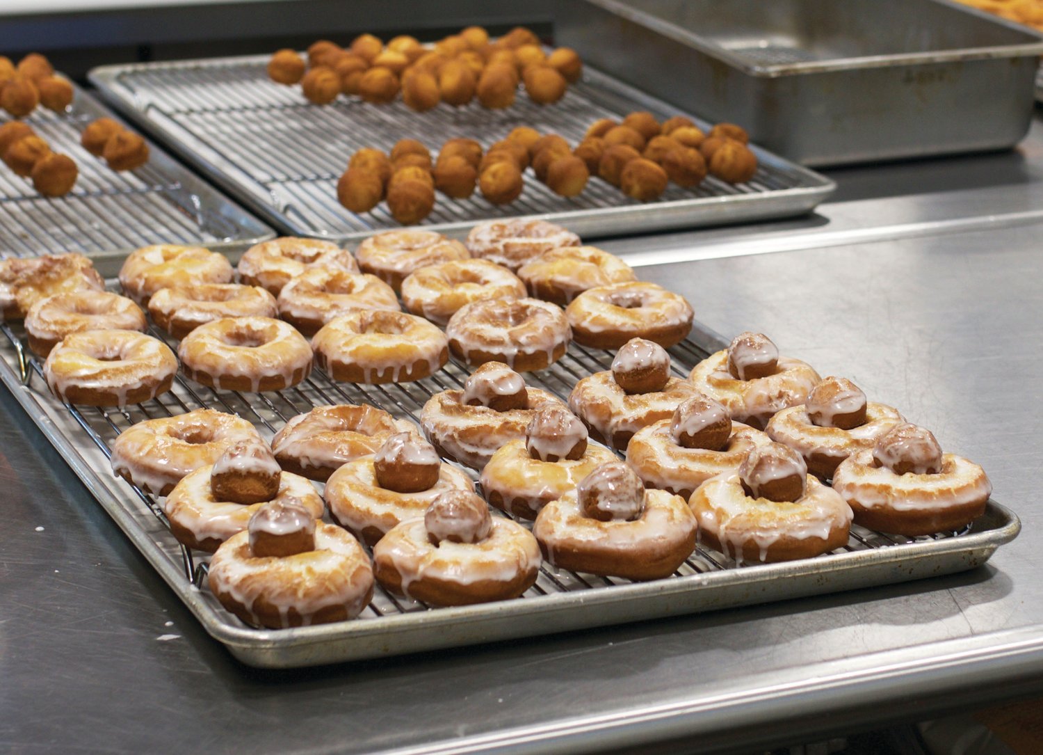 Freshly made donuts are laid out in preparation for being sold and boxed.